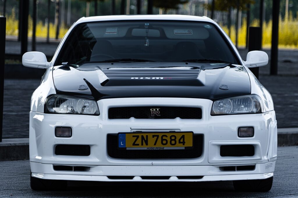 Front view of a sleek white and black Nissan GT-R, elegantly parked on a bustling street.